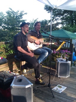 Unplugged performing on a garden deck at dusk