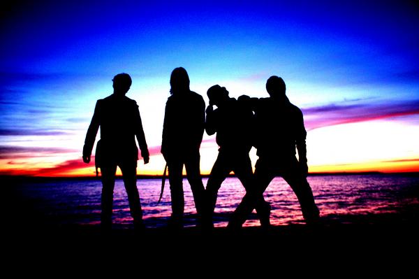 Anovia band silhouettes against a sunset