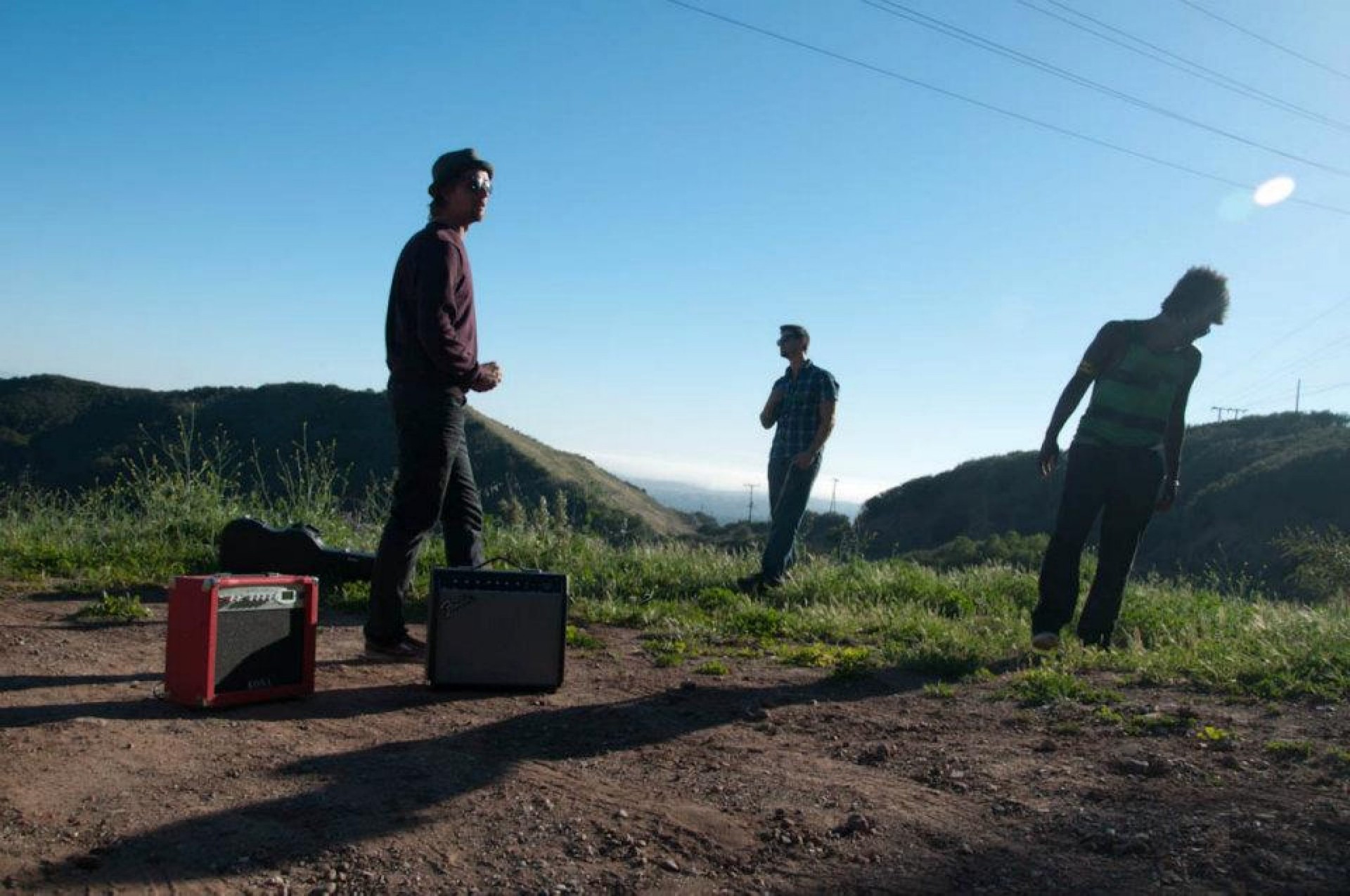 Band members with amps on a hillside above Santa Barbara