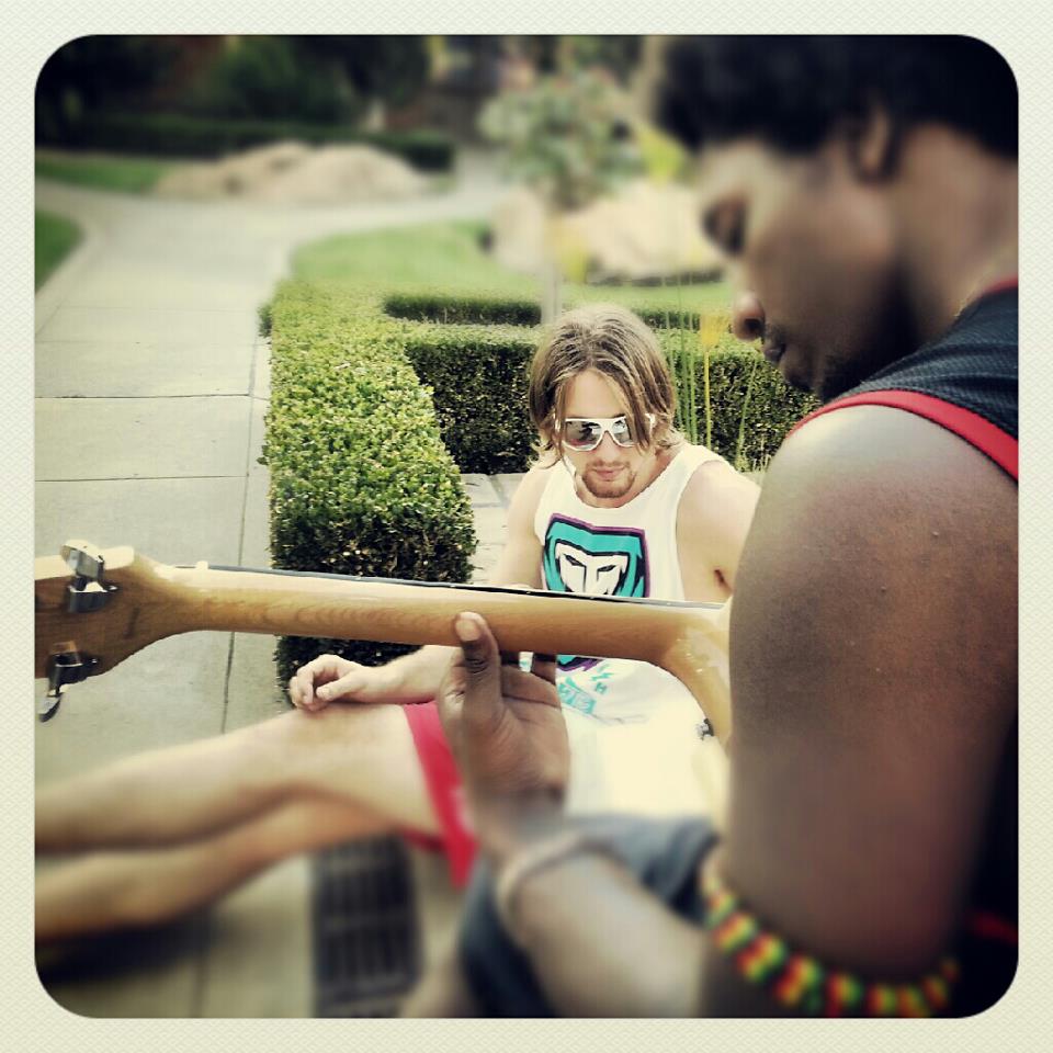 Band members hanging out with a guitar outdoors