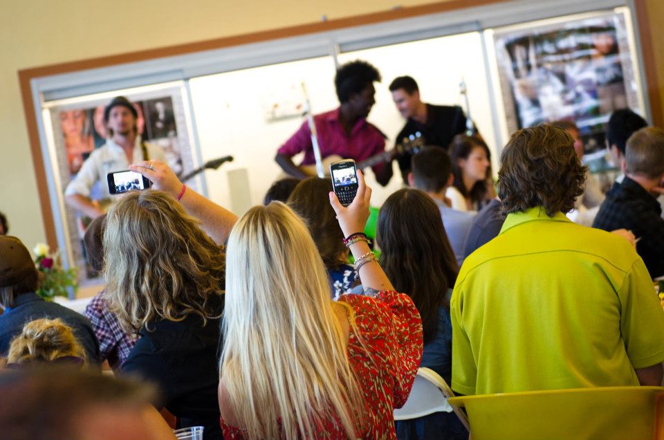 Crowd filming the band with phones at an intimate show